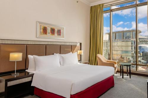 a hotel room with a bed and a large window at Doha Central Plaza Hotel in Doha