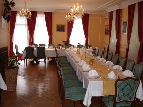 Un comedor largo con una mesa larga y sillas. en Penzion Gostilna Keber, en Domžale