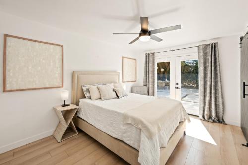 a white bedroom with a bed and a ceiling fan at Private Pool Escape Casita Mini Golf 4BR in Indio