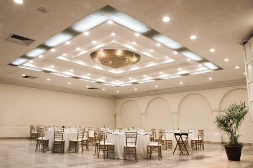 a banquet hall with tables and chairs and a chandelier at Radisson Hotel & Convention Center Toluca in Toluca