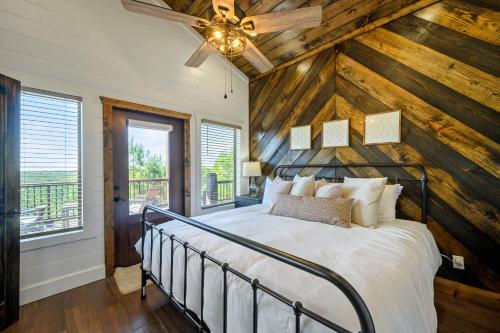 a bedroom with a bed with a wooden wall at Spa Game Room Sunset Views 5BR Cabin in Broken Bow
