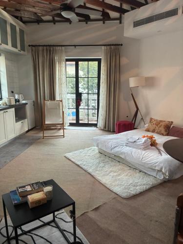 a bedroom with a bed and a table in it at Shanghai Historical Forest Cabin loft With Balcony at second floor near middle Huaihai road in Shanghai