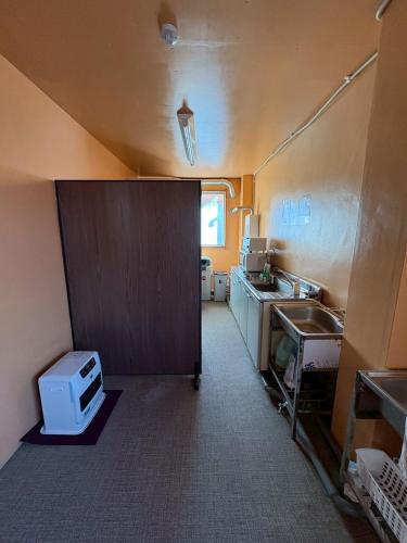 a small kitchen with a sink and a counter top at 駅本ビル民宿4階 in Yuzawa