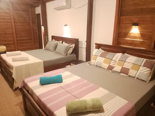 ein Hotelzimmer mit zwei Betten, auf denen Handtücher liegen in der Unterkunft Sandy Beach Hotel in Arugam Bay