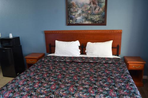 a bed with two pillows and a picture on the wall at Corcoran Inn in Corcoran