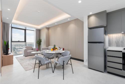 a kitchen and living room with a table and chairs at Samaya Holiday Homes - Cloud Stylish Suites with Balcony in Dubai