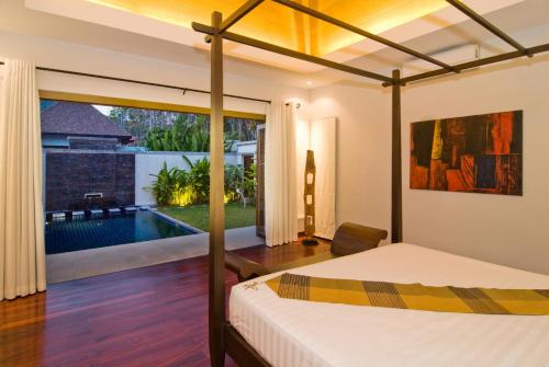 a bedroom with a bed and a swimming pool at Villa Kama in Rawai Beach