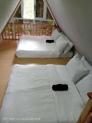 two beds with white sheets in a room at Bilza A-House in Sagada