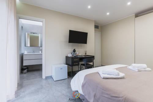 a bedroom with a bed and a desk and a sink at Alma Mare in Crotone