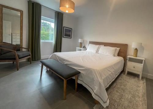 a bedroom with a bed and a chair and a window at Willow in Clifden