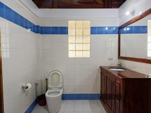 a bathroom with a toilet and a sink at Rainbow Bay Beach & Dive Resort in Siquijor