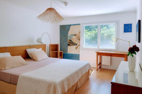 a bedroom with a bed and a desk and a window at UN OASIS EN PROVENCE in Aubagne