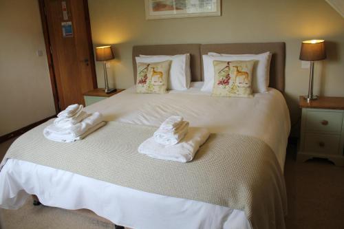 a hotel room with a bed with towels on it at Three Horseshoes Country Inn in Barry