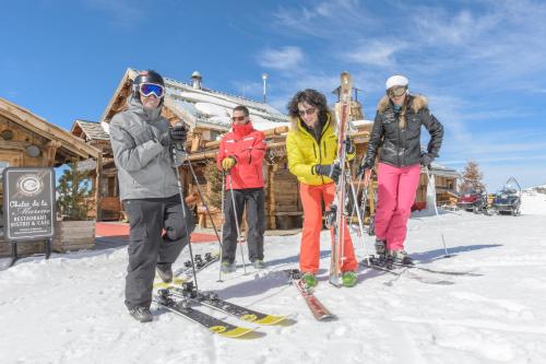 een groep mensen die in de sneeuw voor een hut staan bij Temples Du Soleil Tikal Appartements VTI in Val Thorens