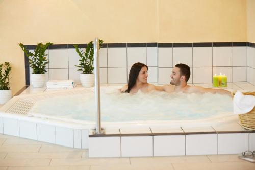 a man and a woman in a bathtub at Wander- & Wellnesshotel Nägele in Höchenschwand