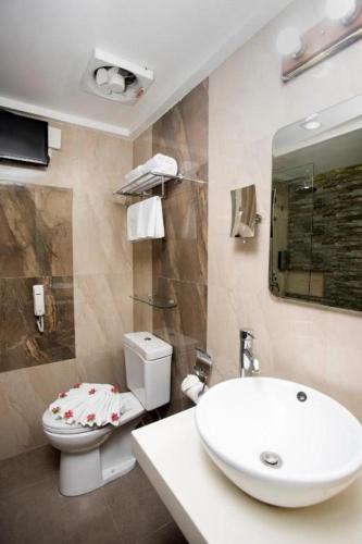 a bathroom with a white toilet and a sink at Red Coco Inn de Boracay in Boracay