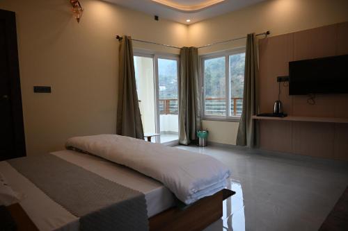 a bedroom with a bed and a large window at Hotel Highway Nest in Chamba