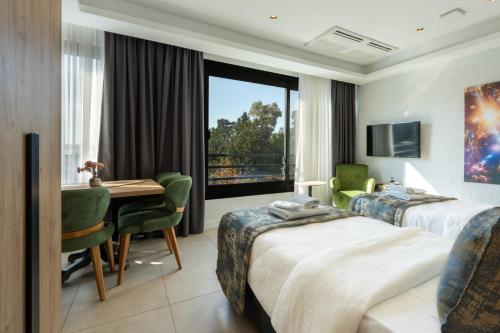 a hotel room with two beds and a desk and a window at Taga Hotel in Bitez