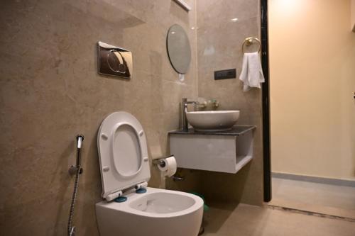 a bathroom with a toilet and a sink at Hotel Highway Nest in Chamba