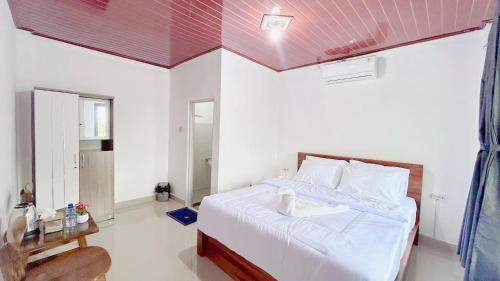 a bedroom with a bed with a pink ceiling at Mars Homestay Ubud in Ubud