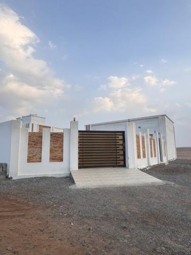 un edificio con una grande porta in mezzo a un campo di استراحة العفية a Sur