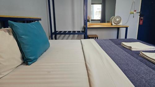 a bedroom with a bed with a blue pillow at Blueplace บลูเพลส in Ban Talat Rangsit