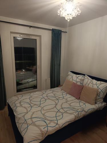 a bedroom with a bed in a room with a chandelier at Perła Residence in Kutno