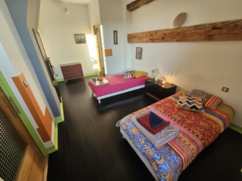 a bedroom with two beds in a room at La Ferme Bugiste - Maison de caractère in Belley