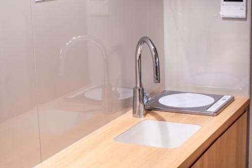 a kitchen counter with a sink and a shower at Hotel Naranohamori in Nara