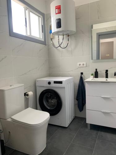 a bathroom with a toilet and a washing machine at Pandora apartment in Las Galletas