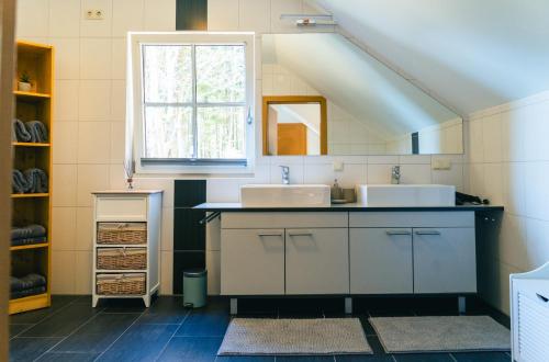 a bathroom with two sinks and a window at Ferienwohnung Kahlseneck in Fischerndorf
