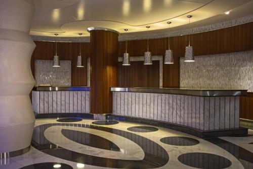 a lobby with a bar and chandeliers in a building at Renaissance Izmir Hotel in İzmir