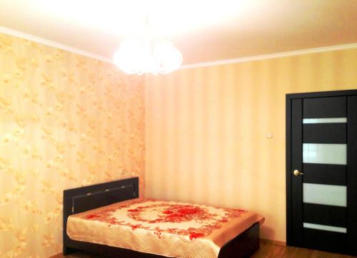 トリヤッチにあるApartment on Sportivnayaのベッドルーム1室(ベッド1台、シャンデリア付)