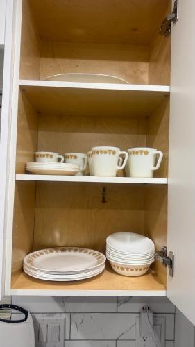 a cabinet filled with plates and cups and dishes at J & J Dream Villa Ltd in Abbotsford