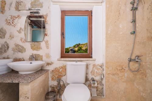 a bathroom with a toilet and a sink and a window at Villa Elvin in Kalkan