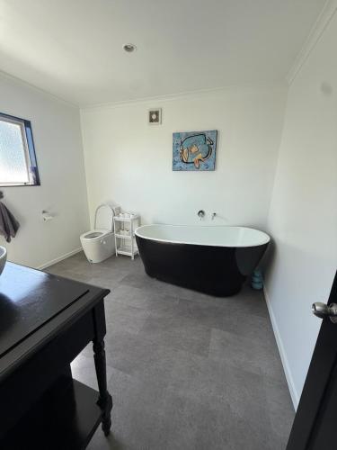 a bathroom with a black and white bath tub at City centred living! in Palmerston North