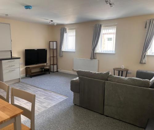 a living room with a couch and a flat screen tv at Easy Living Stays Burton on Trent in Burton upon Trent