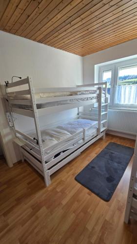 a white bunk bed in a room with a wooden ceiling at Ferienhaus check ferien dot world in Berenbach