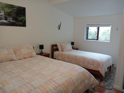 a bedroom with two beds and a window at Rata Lodge Accommodation in Otira