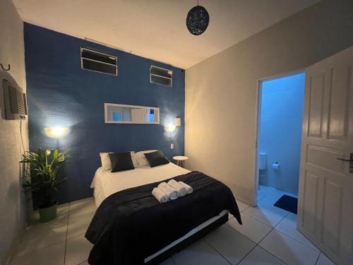 a bedroom with a bed and a blue wall at Casa La France in Caucaia