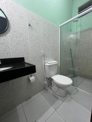 a bathroom with a toilet and a glass shower at Casa La France in Caucaia