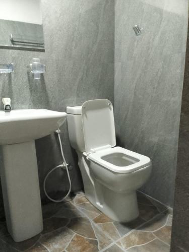 a bathroom with a white toilet and a sink at Moonlight Resort in Anuradhapura