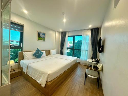 a bedroom with a bed and a desk and window at Sky Hotel in Ninh Binh
