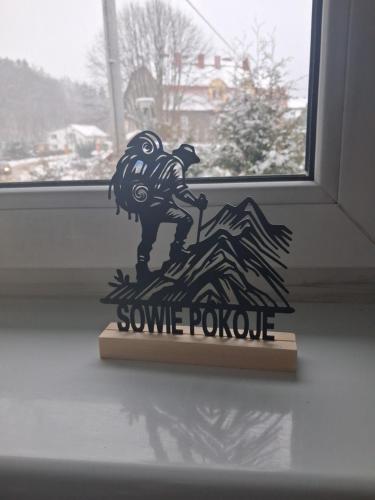 a statue of a dog on a mountain in front of a window at Sowie Pokoje in Jugów