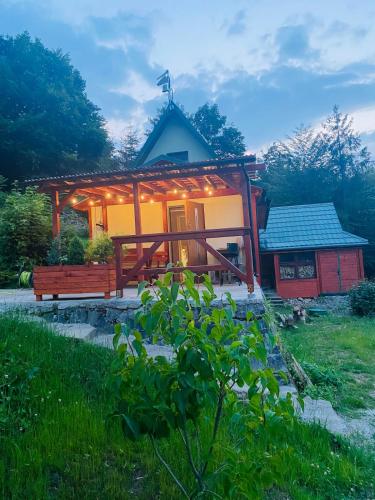 a house with a bench in front of it at Pod Srebrzystym Świerkiem - Jacuzzi in Koszarawa