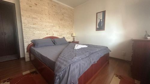 a bedroom with a bed and a brick wall at 2 Rooms Center Ramnicu Valcea in Râmnicu Vâlcea