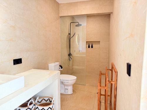 a bathroom with a toilet and a sink and a shower at Villa YAOUH à Seseh in Munggu