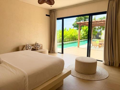 a bedroom with a bed and a view of a pool at Villa YAOUH à Seseh in Munggu