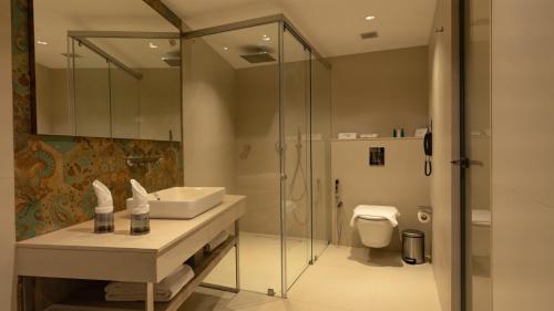 a bathroom with a shower and a sink and a toilet at Coral Reef Kakkanad in Cochin