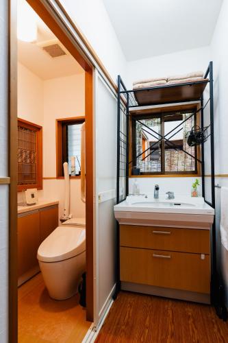a bathroom with a toilet and a sink at ゲストハウス nagatafure in Iki
